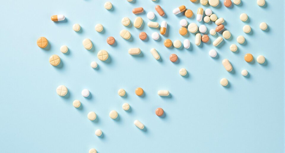 Assortment of Supplement Capsules on Pale Blue Background